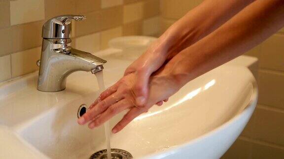 女孩在水龙头下洗手