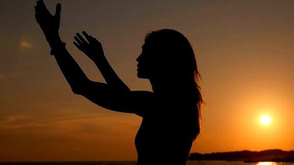 日落时的放松:孤独的女人在看日落时放松