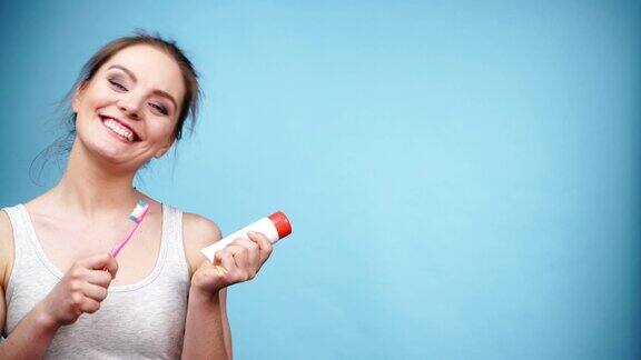 女人手持4K牙刷和牙膏清洁牙齿