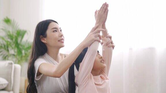 母亲和女儿在家里练习瑜伽