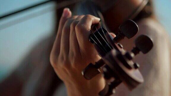 小提琴家在户外拉小提琴绿叶backgound关闭了音乐家演奏慢动作