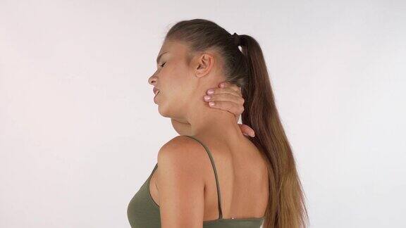 年轻女子按摩她的脖子后关节疼痛