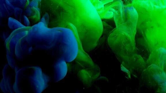 绿色和蓝色霓虹涂料在黑暗的空间混合创造各种艺术形状