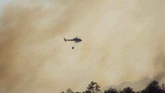 消防直升机在森林大火上洒水