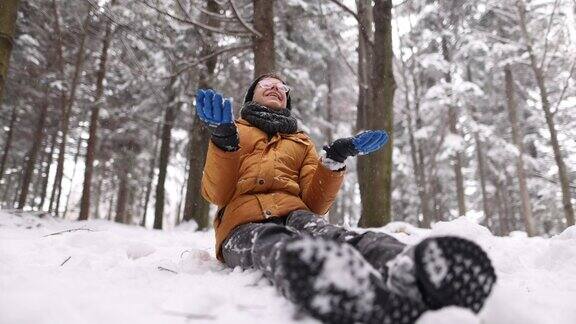 小男孩坐在雪地上享受冬天