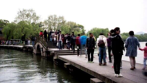 游客走在西湖的石桥上时光流逝