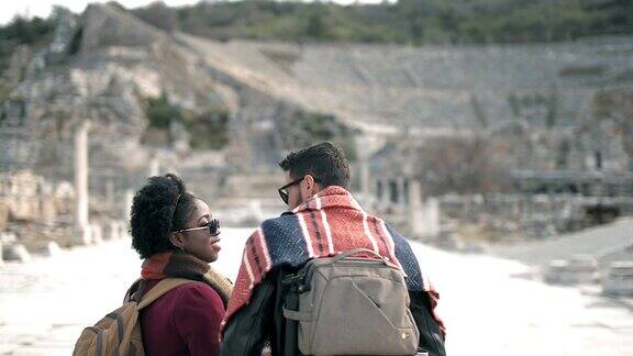 一名白人男子和一名非洲女子参观一座古城