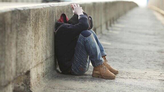 无家可归的小男孩睡在桥上