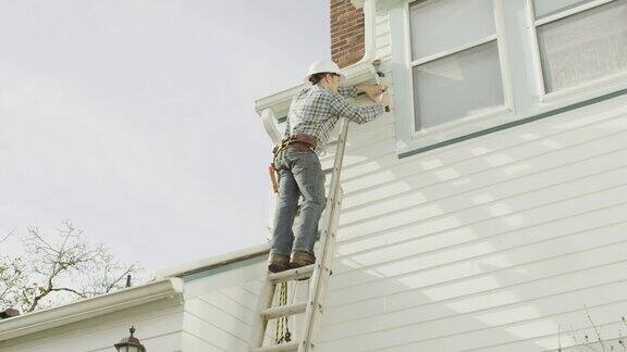 建筑工人爬上梯子在住宅上干活