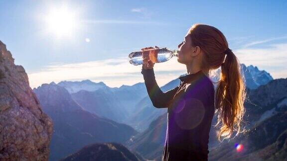 在山顶喝水的年轻女子