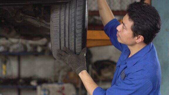 4k:男修理工在汽车修理店检查轮胎