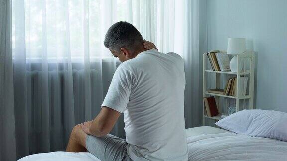 男人主动按摩他麻木的脖子感觉疼痛后质量不好的枕头