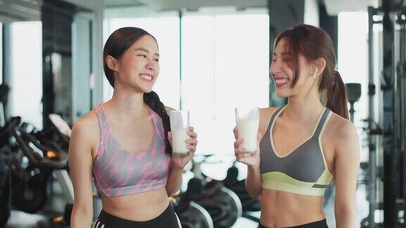迷人的健身亚洲女性完成锻炼并在训练后饮用蛋白质牛奶奶昔维生素健身健康的生活方式