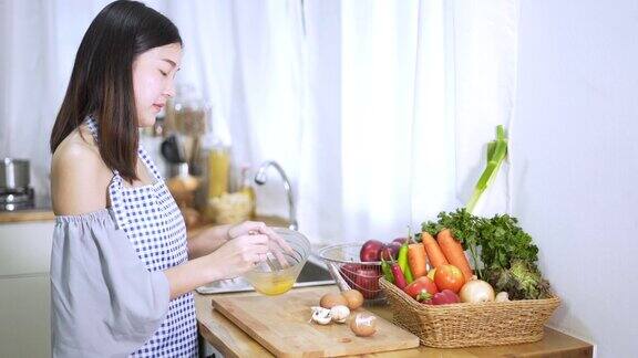 女人在厨房做饭年轻的亚洲女人在厨房切蔬菜健康的食物和烹饪概念