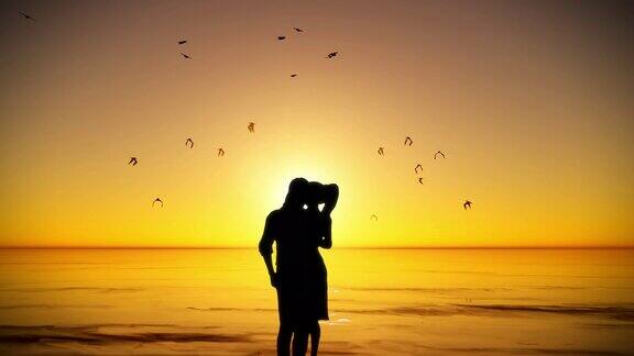 一对情侣的剪影在水边金色的夕阳前亲吻拥抱