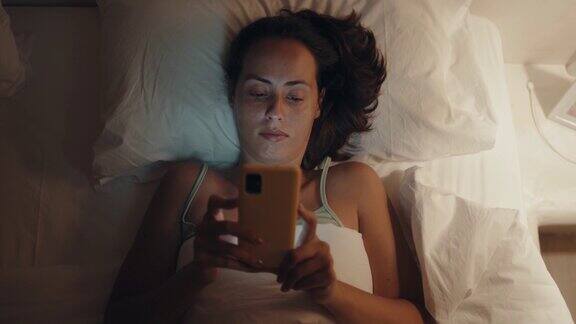 躺在床上浏览社交媒体的女人