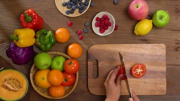 女人用手在木桌上切西红柿