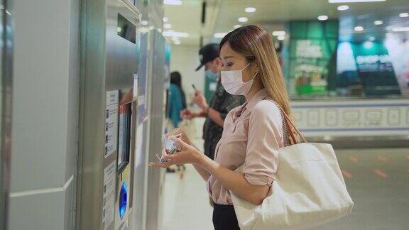 一名年轻女子在自动贩卖机购买公共交通车票