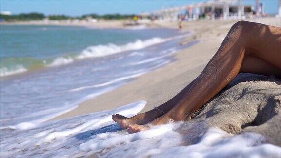 女人的腿特写在海滩在暑假