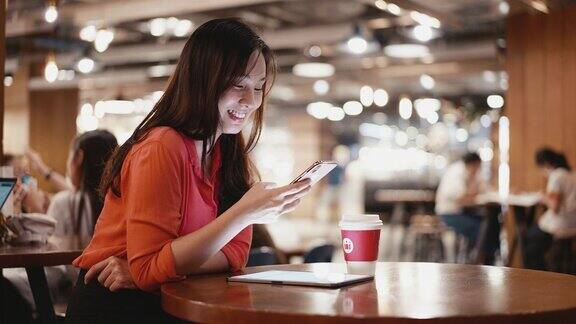 一名年轻女子在咖啡馆使用智能手机