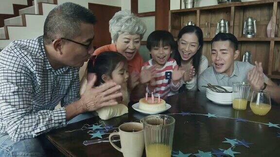 几代同堂的中国家庭吹生日蛋糕蜡烛