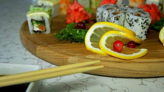 多莉拍摄美味的寿司卷在木盘子与芥末和生姜