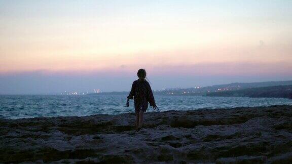 女孩跑在海边附近的海边在日落塞浦路斯