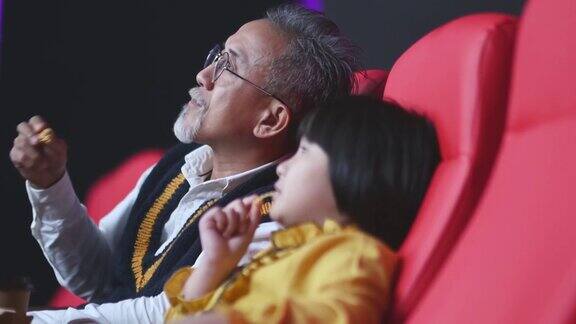 亚洲华人活跃的老人和他的孙女喜欢在电影院看电影
