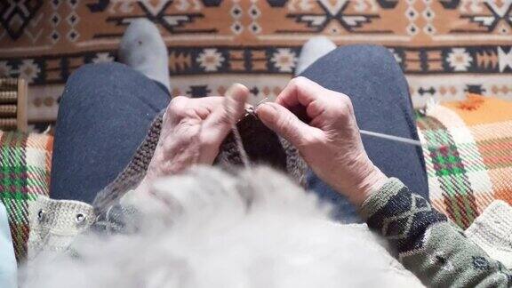 观点一位老人织着精致而美观的毛衣近处是一位老奶奶满是皱纹的双手正在织一件新的冬季毛衣活跃的退休老人