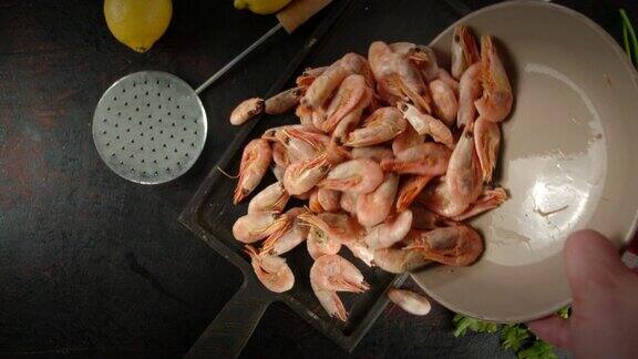 从碗里取出煮好的虾放在砧板上
