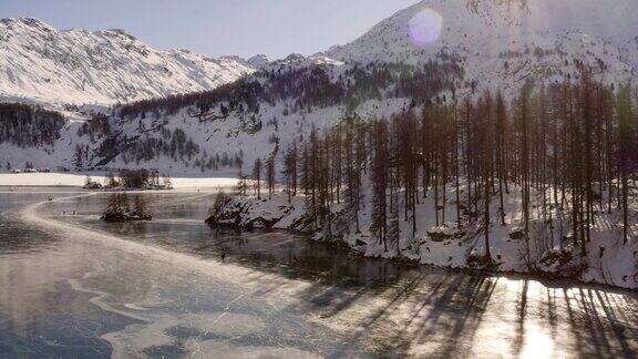 无人机鸟瞰日出时冰冻的湖面冬季无人机在阿尔卑斯湖上空飞行