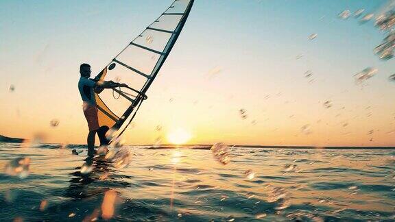 夕阳下男人们在湖边帆板冲浪