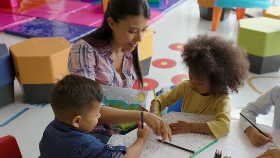 在美术课上慈爱的老师引导学生给孩子们示范让孩子们着色