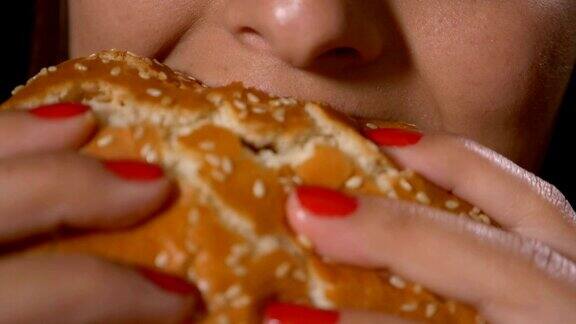 慢镜头近距离饥饿的年轻女子吃垃圾食品、不健康的快餐、三明治、汉堡包