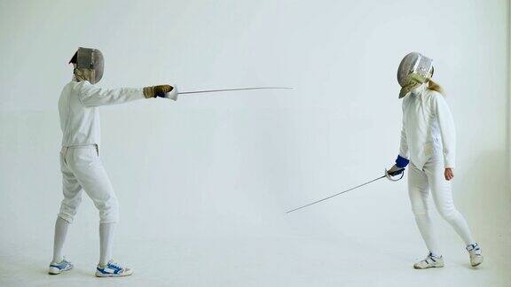 两名击剑运动员在白色背景下进行击剑攻击训练