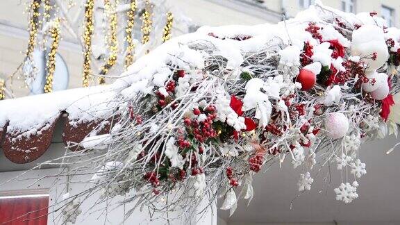 莫斯科街道上房顶上覆盖着雪的圣诞装饰品和在风中摇曳的发光的花环