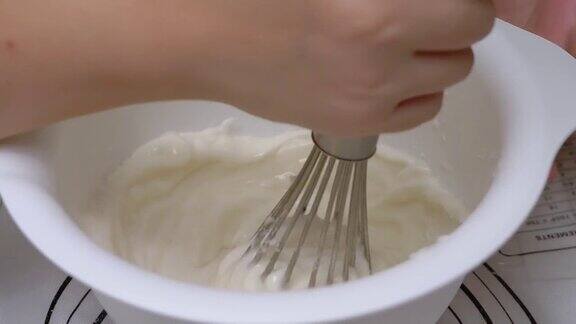 在搅拌碗中愉快地搅拌白糖粉和白鸡蛋
