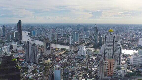 鸟瞰图曼谷市区与湄南河泰国亚洲智慧城市的金融区和商业中心日落时分的摩天大楼和高层建筑