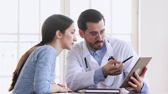 医生向病人展示数字平板电脑的医疗测试结果