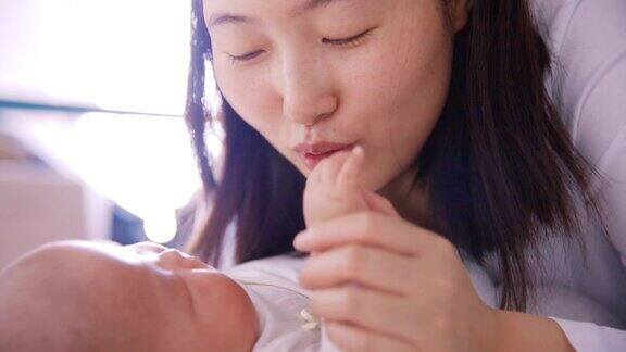 妈妈一边玩一边亲吻宝宝的手
