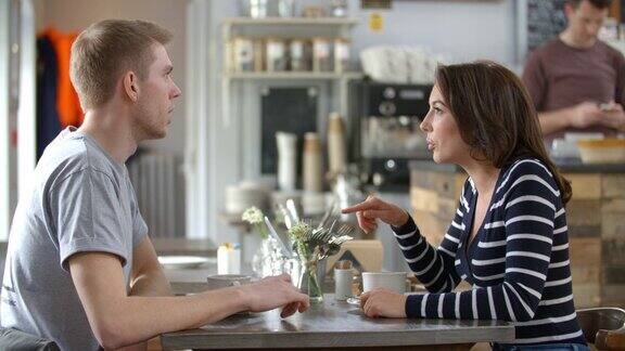 一对成年夫妇在咖啡店的一张桌子上聊天侧视图
