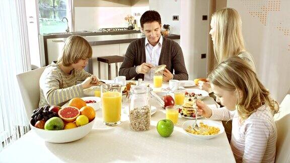 一家人在漂亮的餐桌前吃早餐