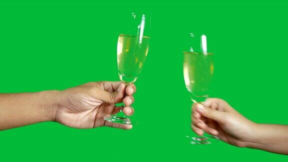 4k两个人互相碰杯与香槟隔离在色度键绿色屏幕背景