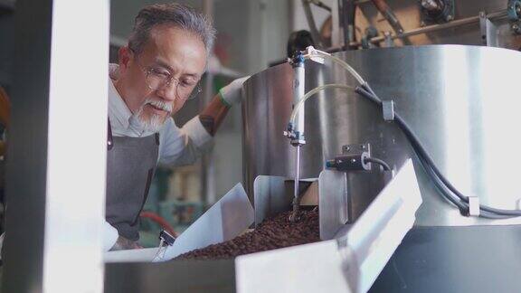 在他的工厂里一名亚裔华裔高级技工正在检查烘培咖啡豆的去石过程