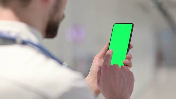 男医生使用带彩色屏幕的智能手机