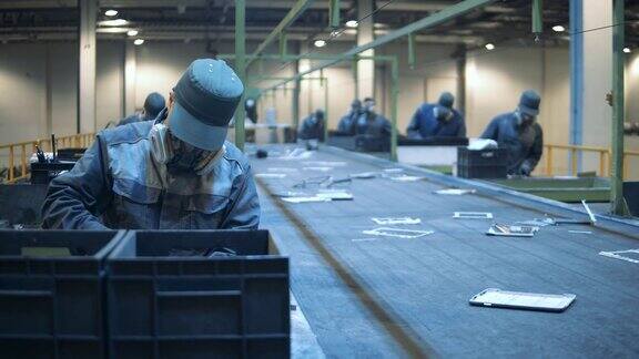 垃圾填埋工人正在对有缺陷的电子产品进行分类工厂的男性员工正在分类垃圾