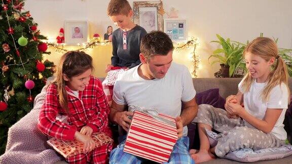 一个单身父亲和孩子们在圣诞节打开礼物