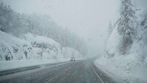 在高速公路上行驶的汽车挡风玻璃上飘落的雪
