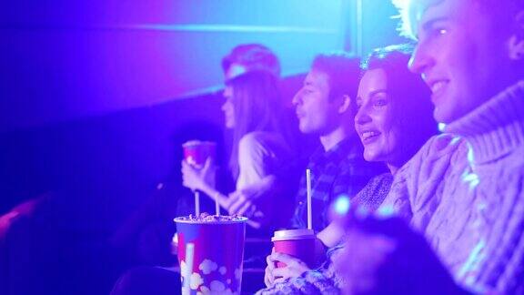 一群青少年朋友在电影院看电影吃爆米花
