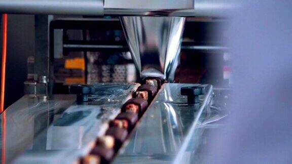 食品包装线甜食生产线食品加工工厂芝士棒的包装工艺食品工厂巧克力工厂传送带上的巧克力甜点食品行业